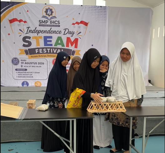 Dari Roket Air hingga Rancang Bangun, Siswa SMP IHCS Balikpapan Rayakan Kemerdekaan dengan Inovasi STEAM para siswi menguji kekuatan jembatan dalam lomba rancang bangun matematika.
